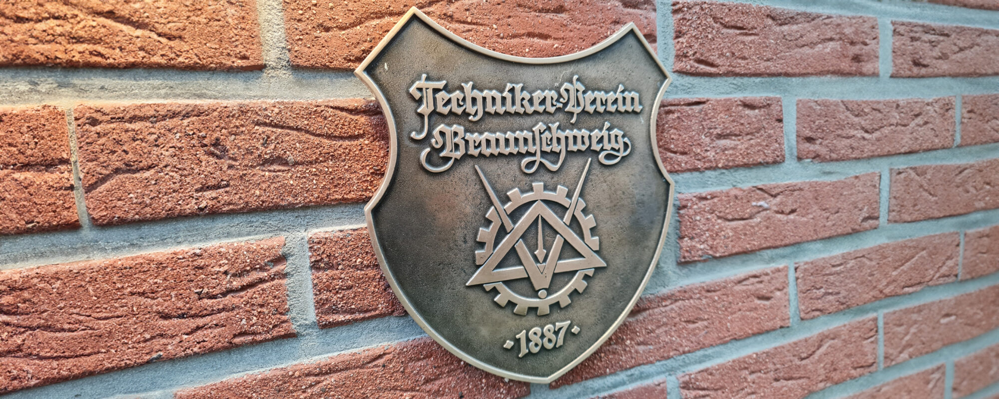 Foto des Wappen "Techniker Verein Braunschweig" an einer Steinwand